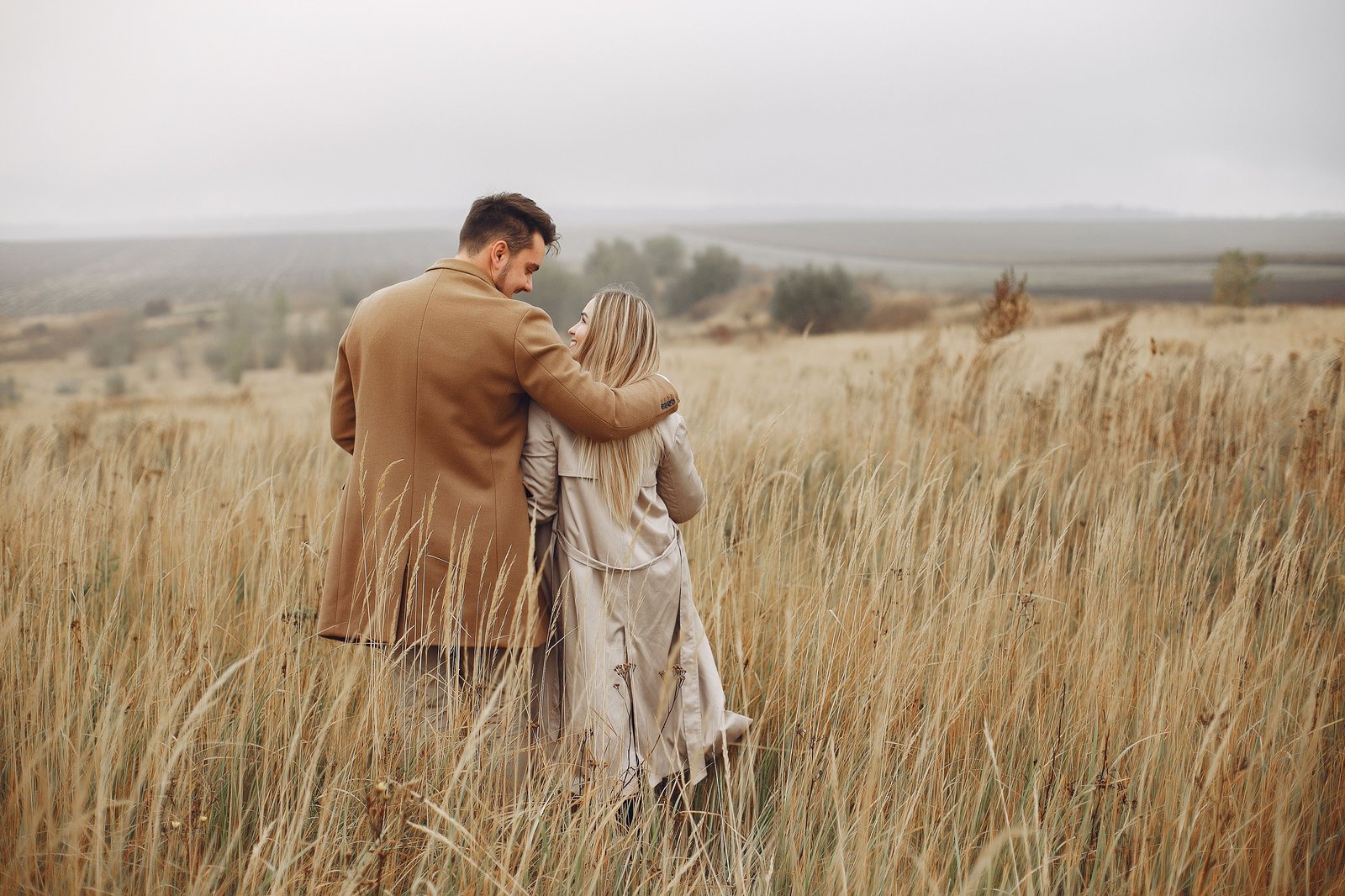 Mature couple walking together through a golden field