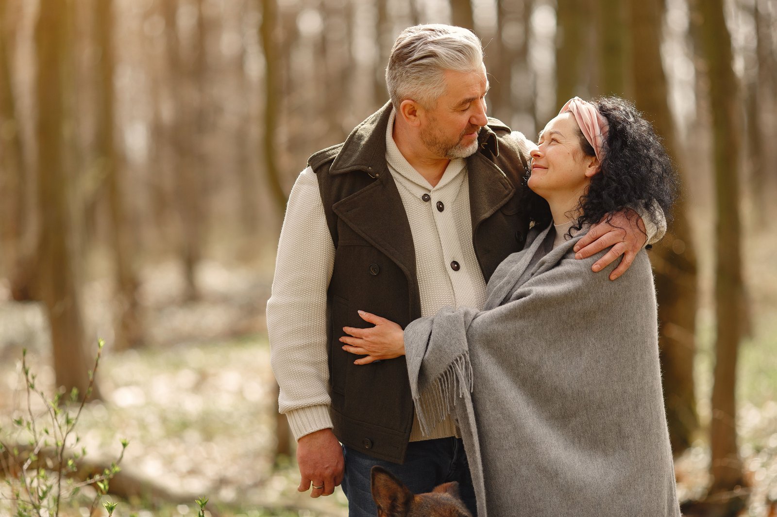 Mature couple embracing on a woodland path